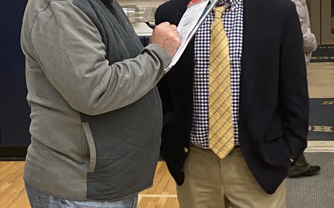 coach talks with a reporter