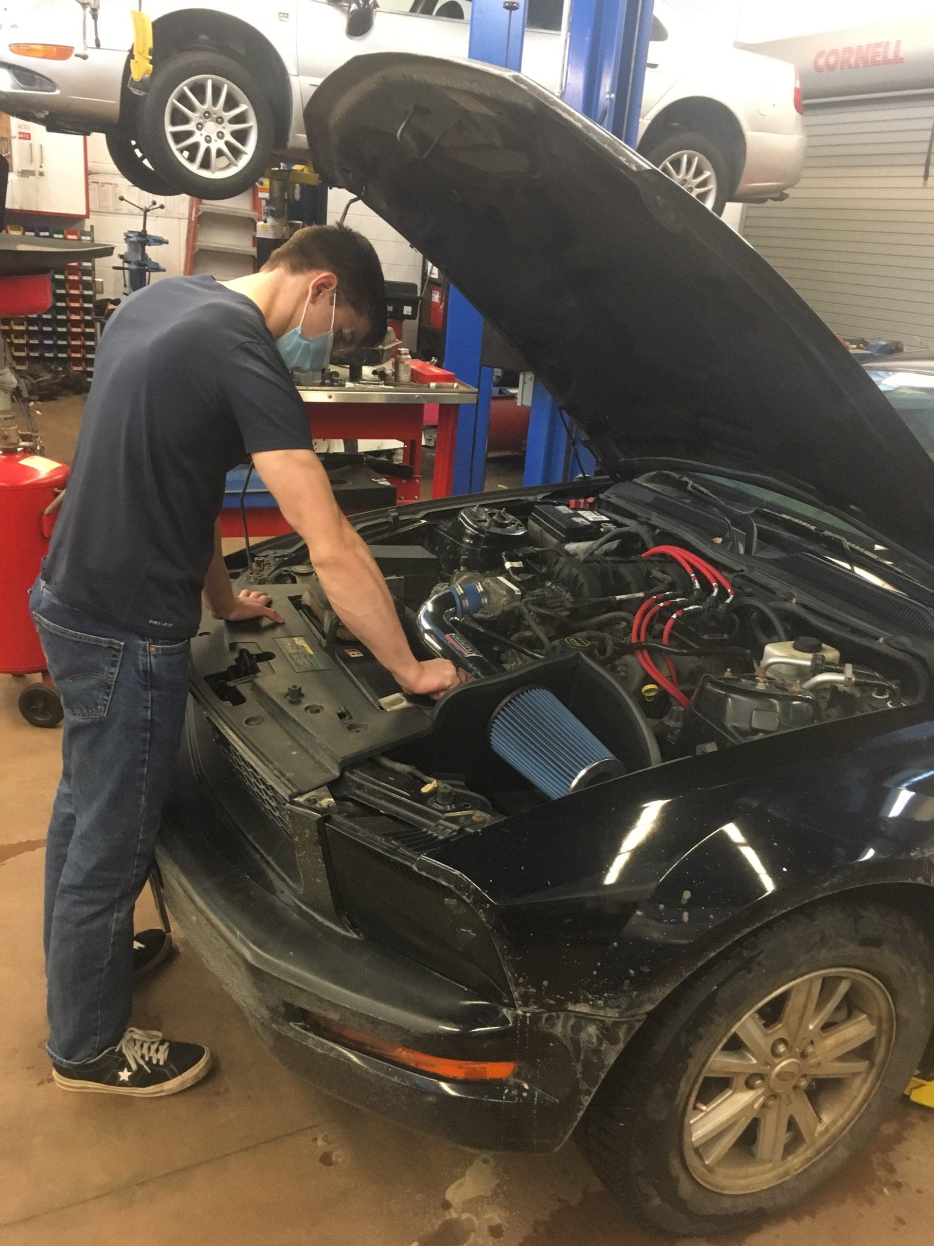 student working on a car